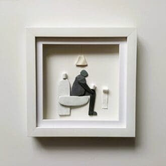 framed humorous picture of a man sitting on the loo holding a roll of toilet paper. Made from slate