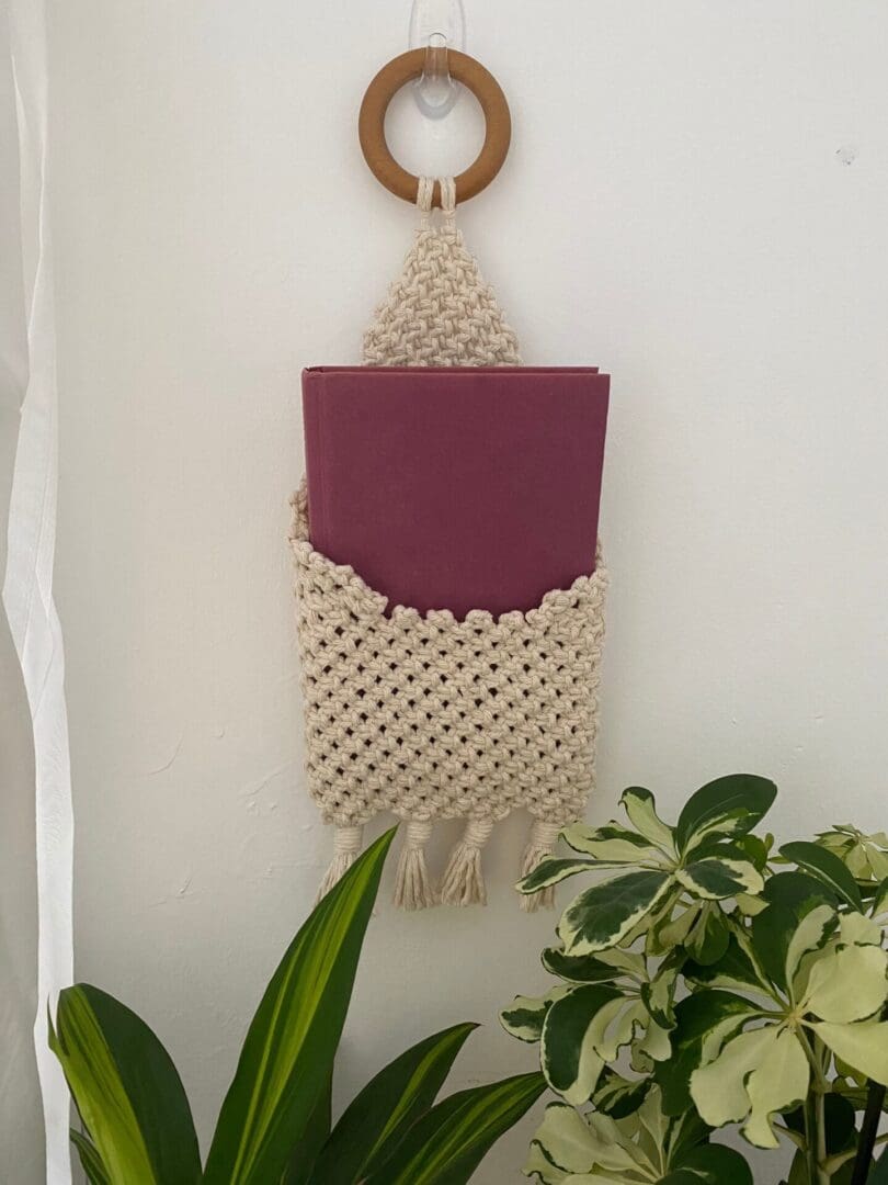 Wall hanging bedside book storage pouch, made with recycled cotton.