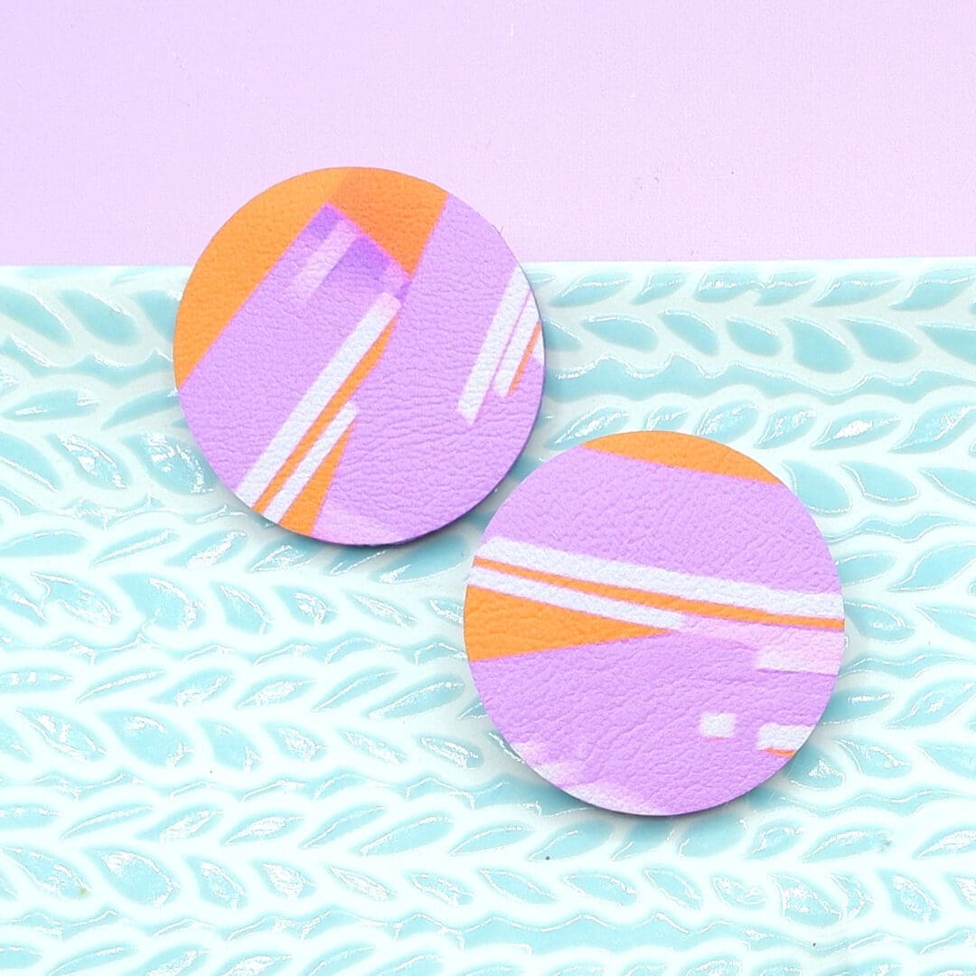 Modern and colourful round stud earrings. Lilac and orange abstract art design. Vibrant and contemporary style