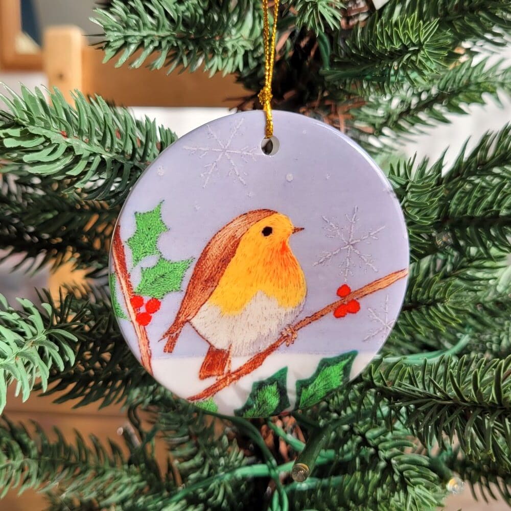 Embroidery print of a robin and holly printed on a ceramic disc to hang on Christmas tree.