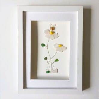 Two flowers in an A4 sized frame made from nuggets of Cornish sea glass