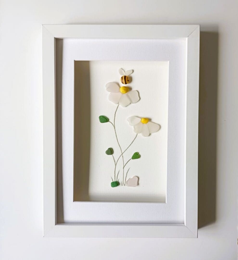 Two flowers in an A4 sized frame made from nuggets of Cornish sea glass