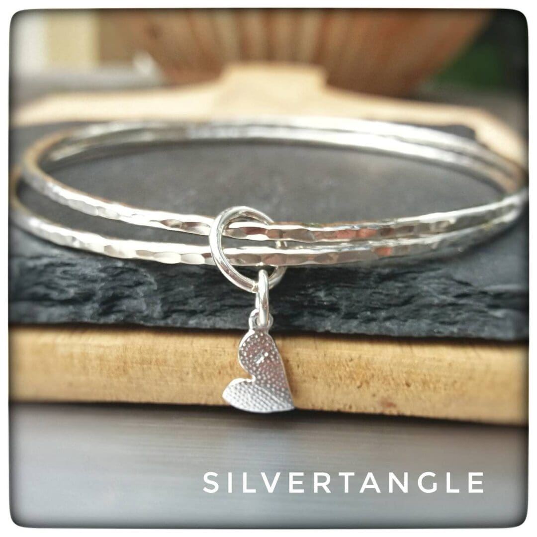 Two Hammered Silver bangles with a Curved Heart Charm