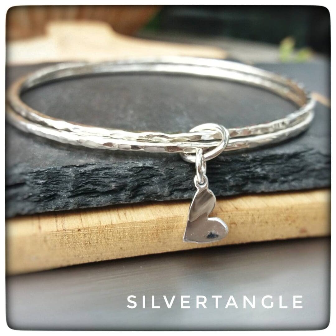 Two Hammered Silver bangles with a Curved Heart Charm