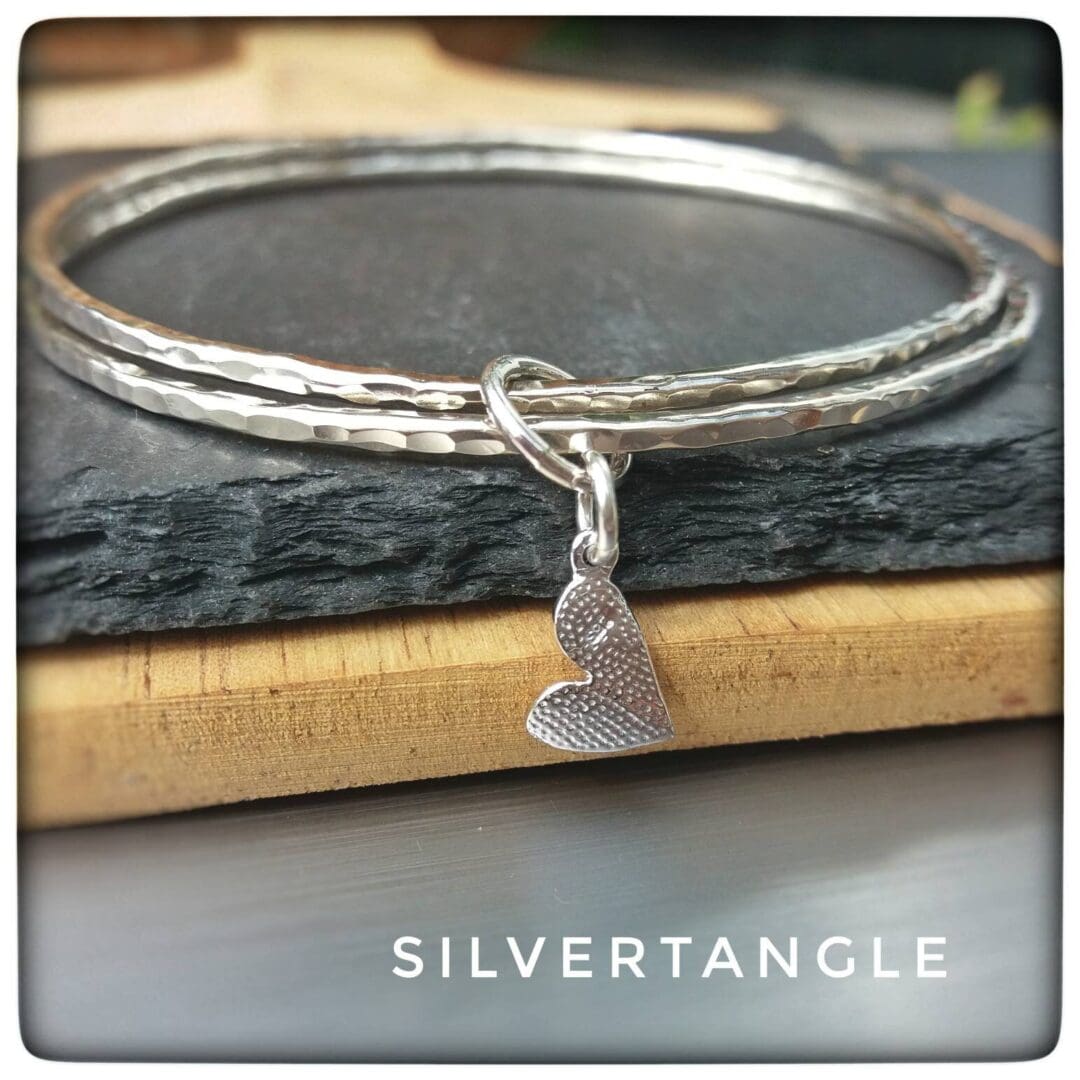 Two Hammered Silver bangles with a Curved Heart Charm