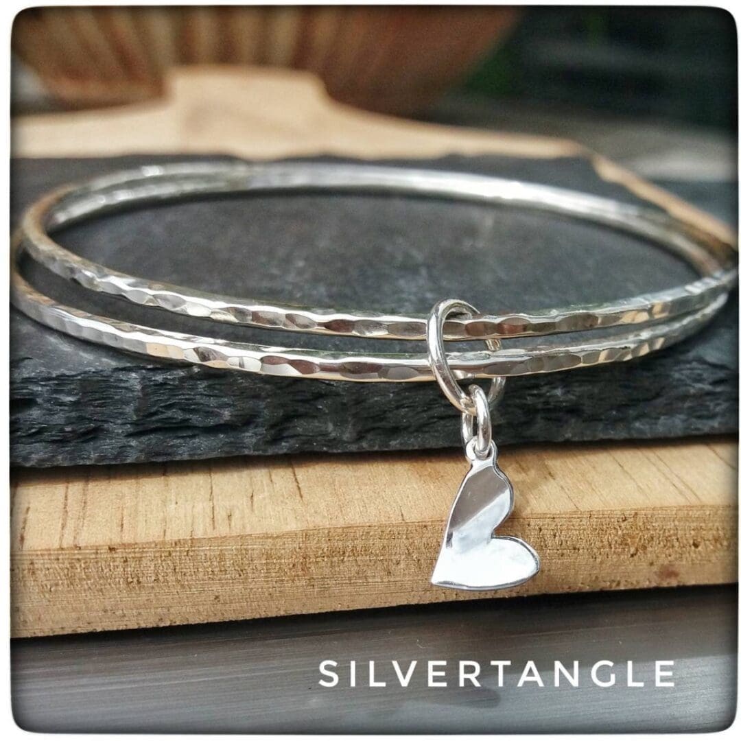 Two Hammered Silver bangles with a Curved Heart Charm