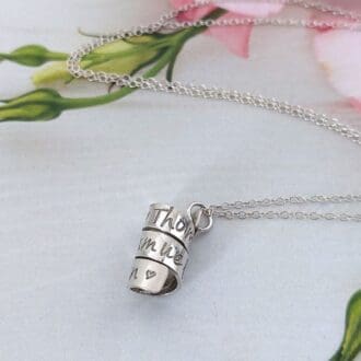 sterling silver necklace featuring a hand-stamped strip coiled into a spiral to create a pendant