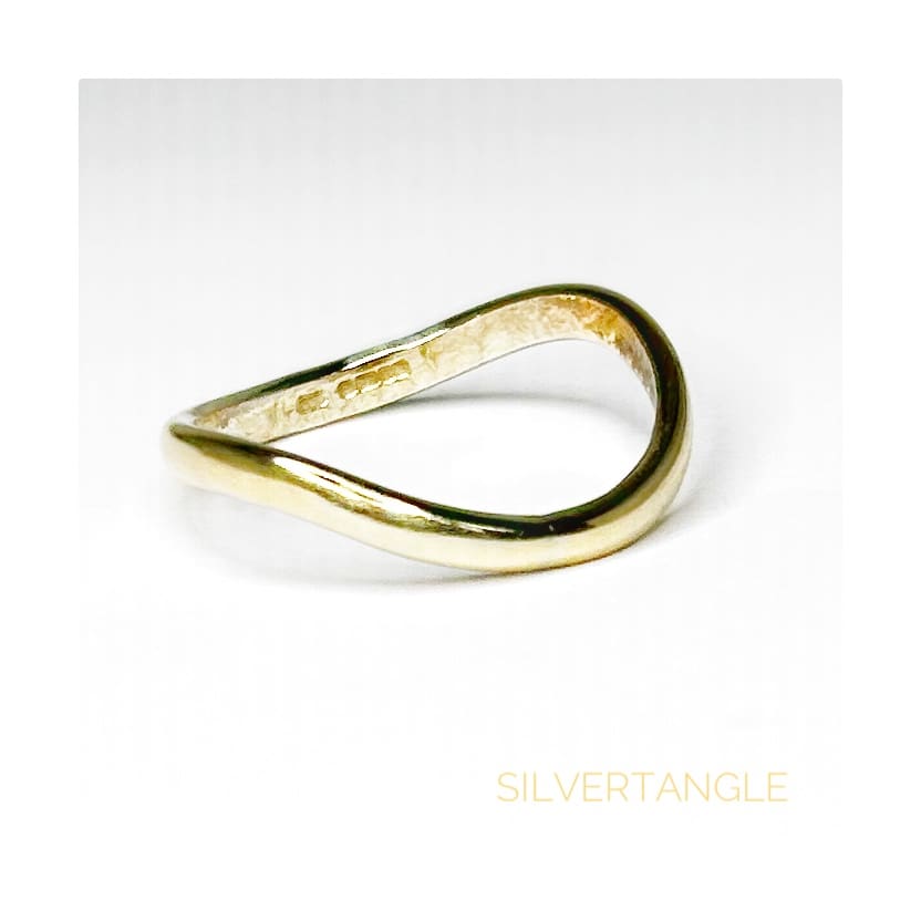 Wavy Gold Thumb Ring on a White Background