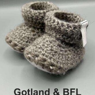 Pair of light grey baby booties crocheted with a sheepskin sole in natural colour Gotland and Blue Faced Leicester wool by Midge Porter Design