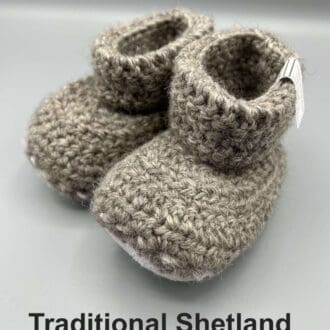 Pair of light grey baby booties crocheted with a sheepskin sole in traditional coloured real Shetland wool by Midge Porter Design