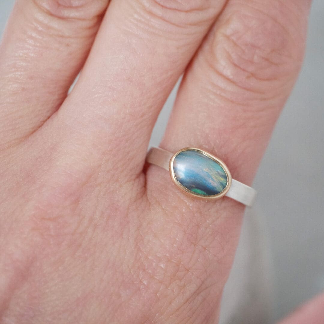 Australian boulder opal ring with 9ct yellow gold bezel and sterling silver, worn