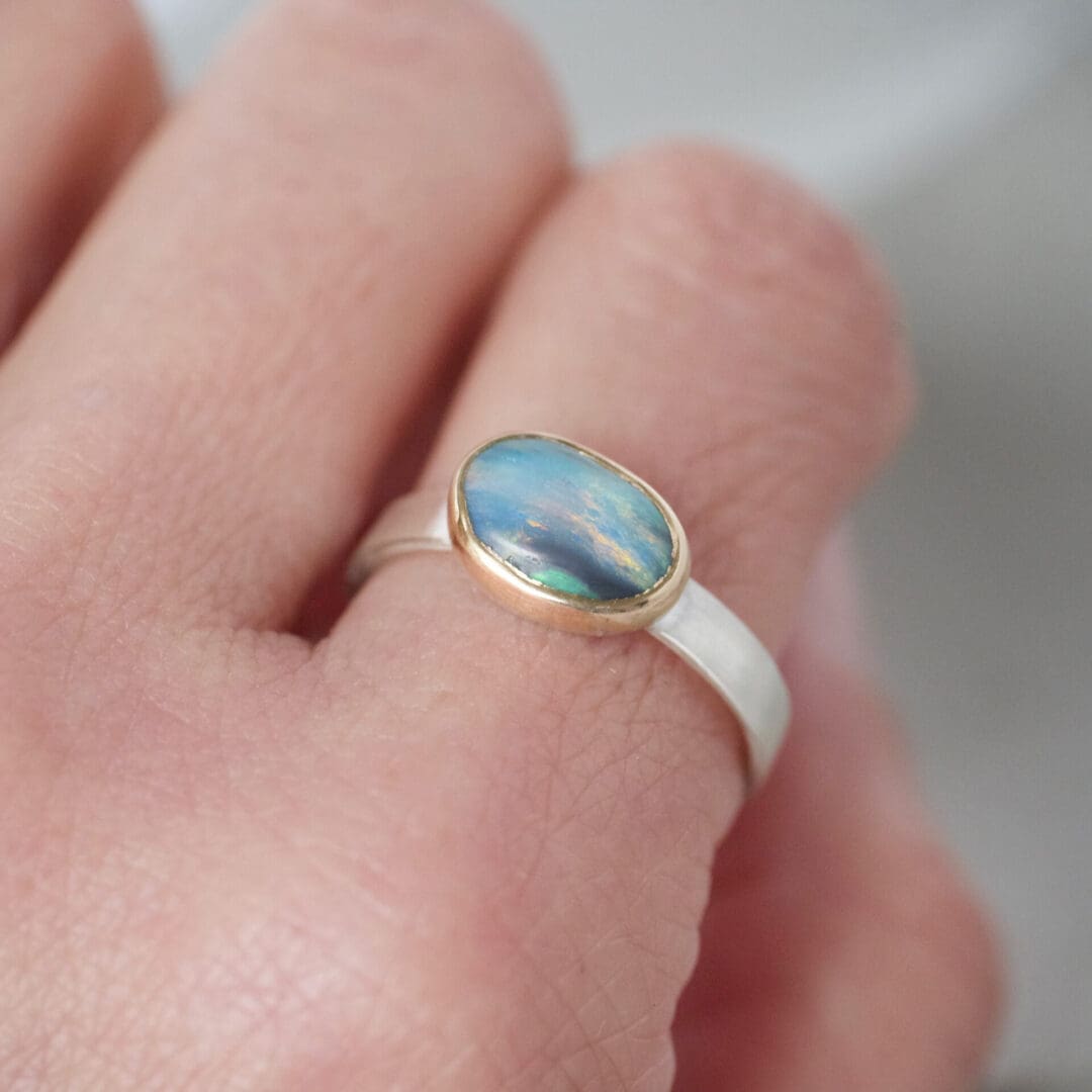 Australian boulder opal ring with 9ct yellow gold bezel and sterling silver, worn