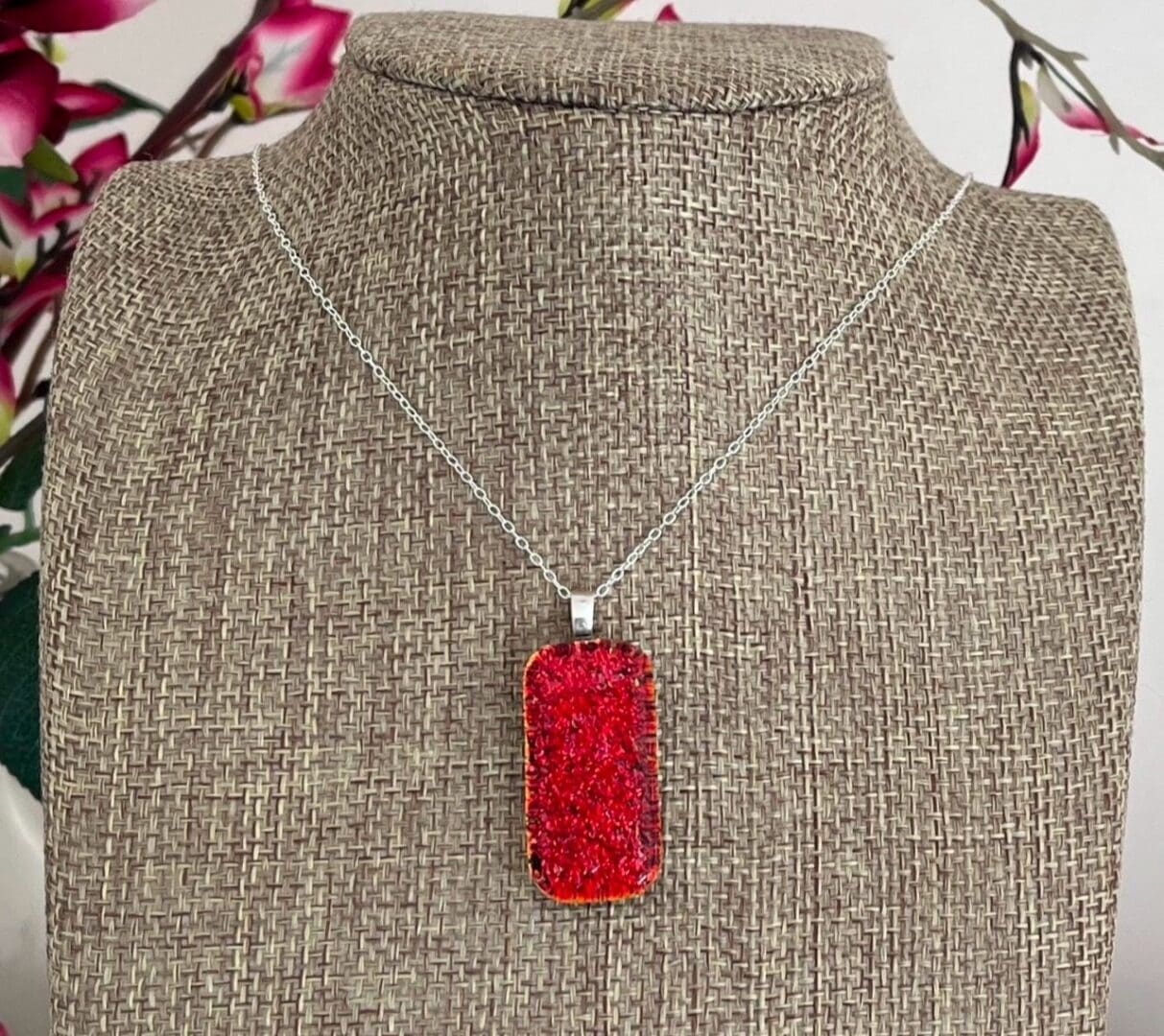 Bright volcanic red sparkly dichroic glass pendant on a sterling silver chain