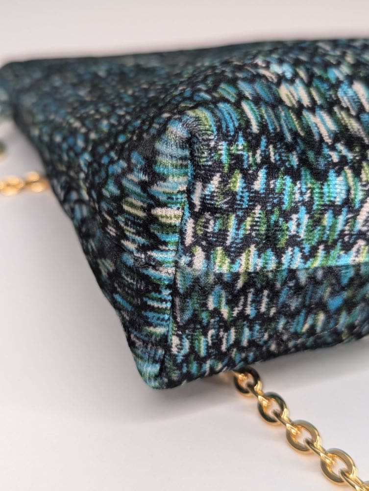 Multicolored patterned bag with a zip closure and gold chain strap, perfect for casual and evening wear