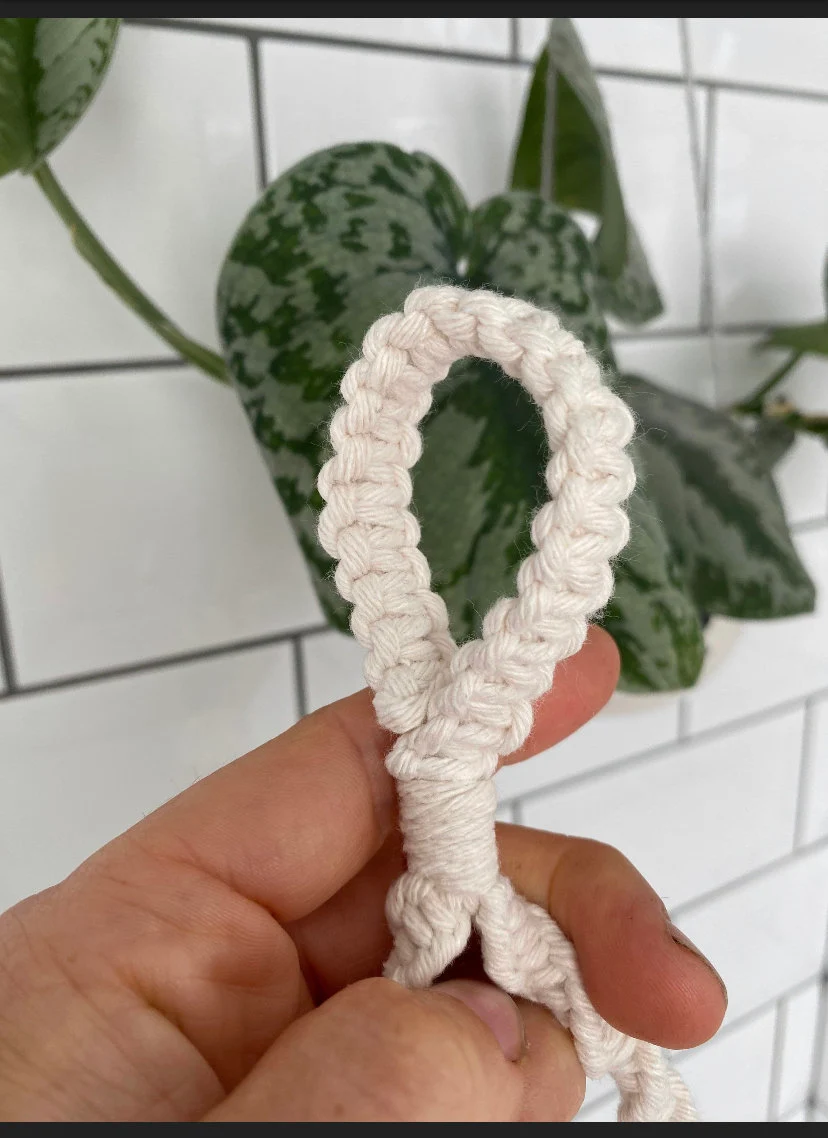 Toilet roll holder with knotted loop finish