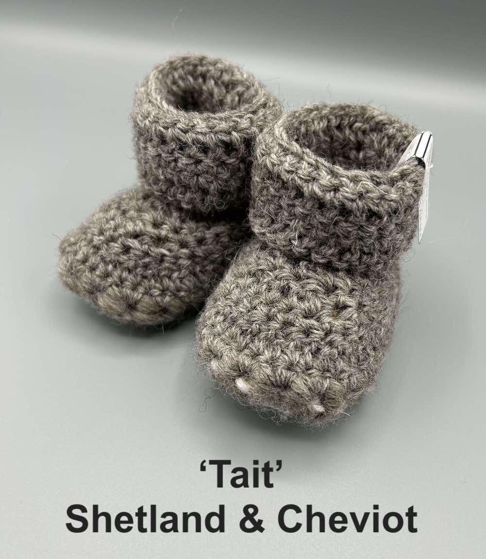 Pair of mid grey baby booties crocheted with a sheepskin sole in Shetland and Cheviot wool by Midge Porter Design