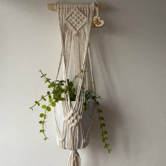 Macrame wall hanging indoor plant holder, made with natural recycled cotton on a wooden dowel.