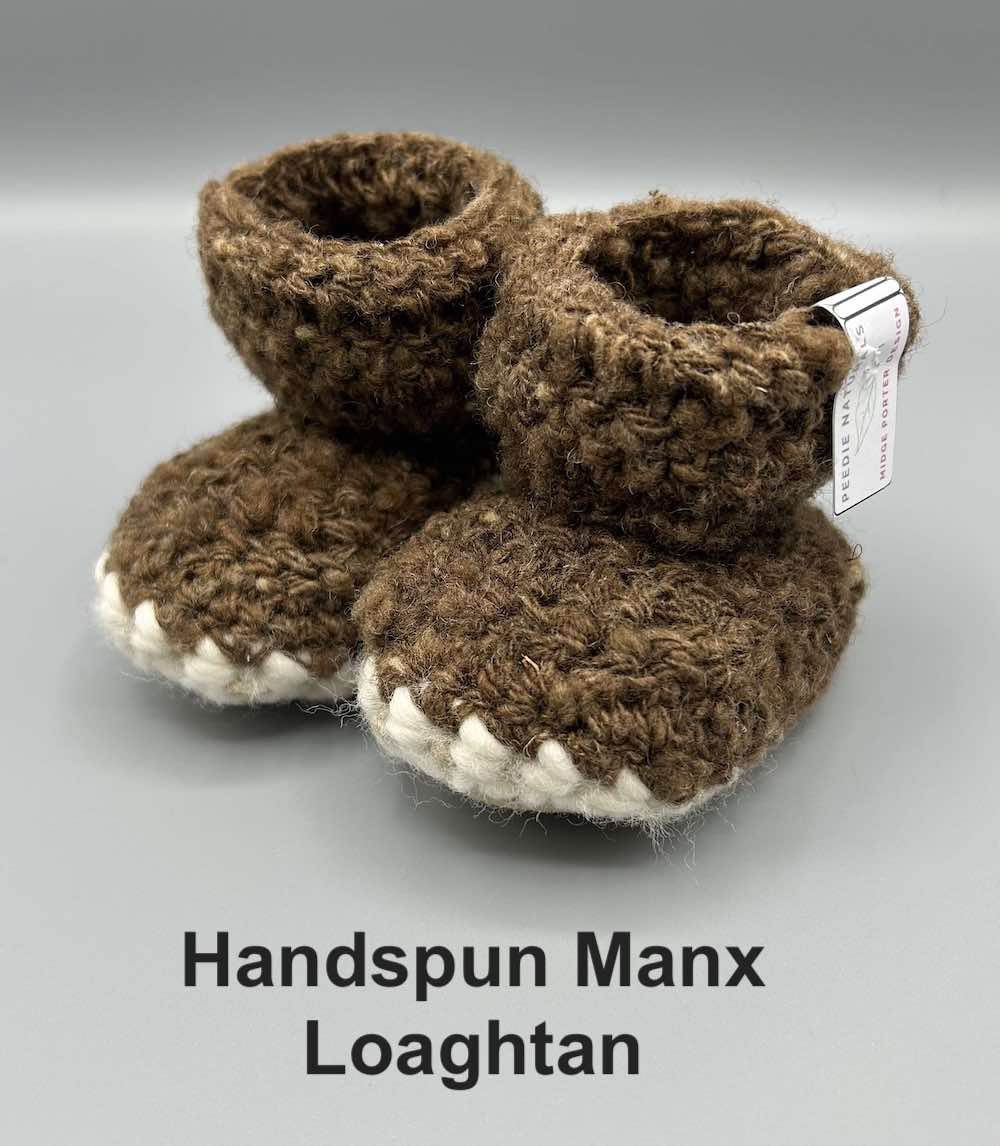 Pair of chocolate brown baby booties crocheted with a sheepskin sole in handspun Manx Loaghtan wool by Midge Porter Design