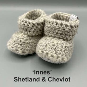 Pair of light grey baby booties crocheted with a sheepskin sole in Shetland and Cheviot wool by Midge Porter Design