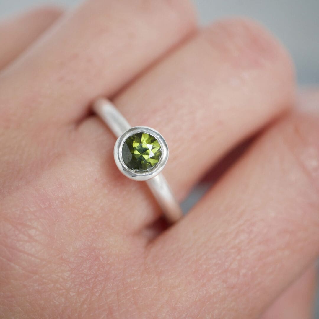 Olive green natural zircon and sterling silver ring worn on the hand