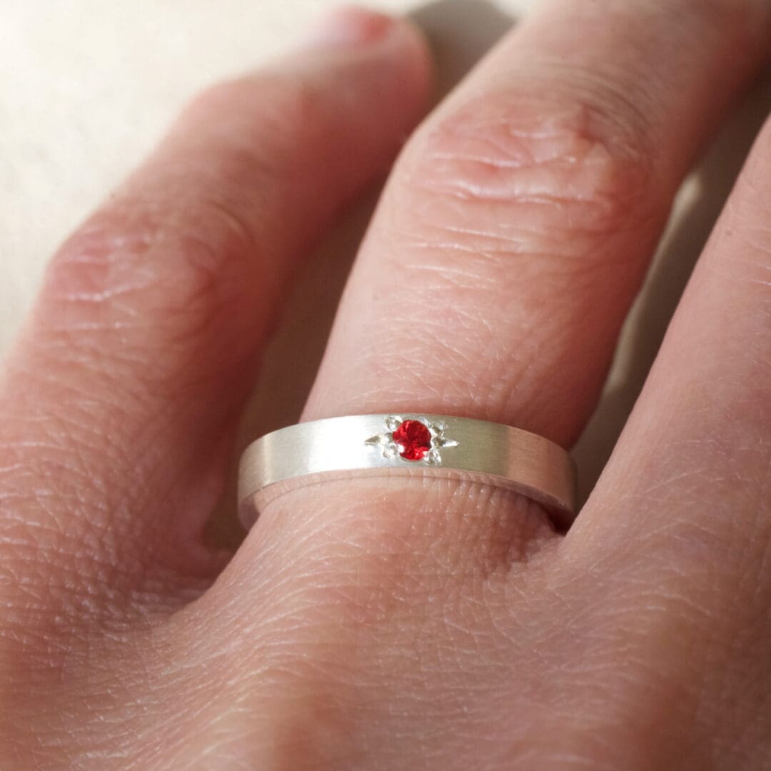 Red sapphire start set argentium silver ring worn on the hand