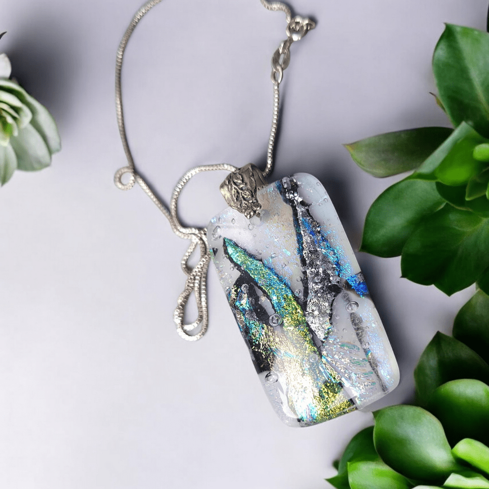 Handmade dichroic glass pendant with vibrant colours, decorative bail, and sterling silver chain, perfect as a bohemian statement necklace or gift for women on occasions like Christmas, Mother's Day, or anniversaries.