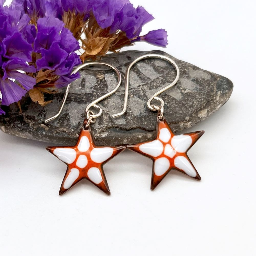 star shaped drop earrings enamelled in orange with white highlights