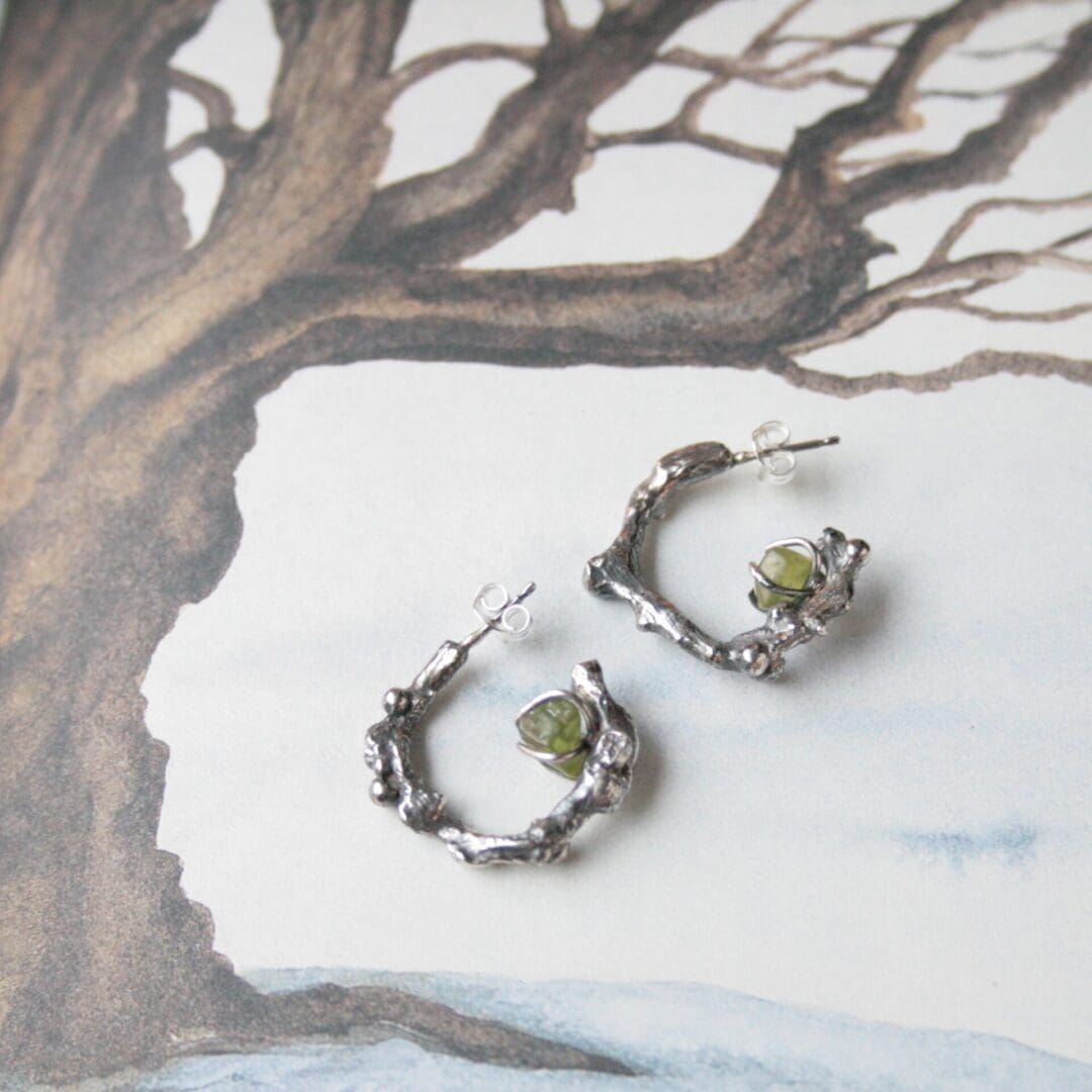 Silver twig hoop earrings with peridot gemstones