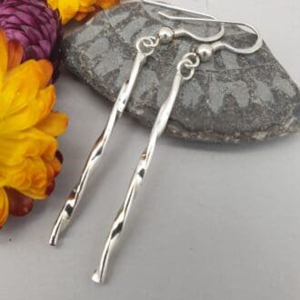 stylish silver long bar earrings with a twisted pattern that really shne in the light on silver ear wires