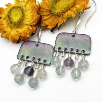 artistic earrings with a enamel lozenge shape that has fluorite and pearl beads suspended to create a fringe of beads all on silver ear wires