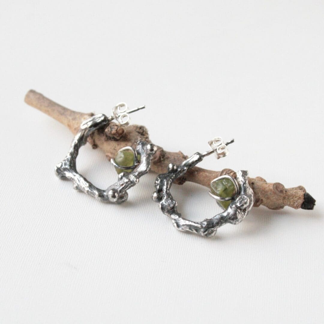 Silver twig hoop earrings with peridot gemstones