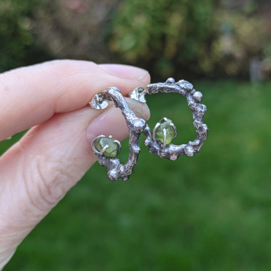 Silver twig hoop earrings with peridot gemstones