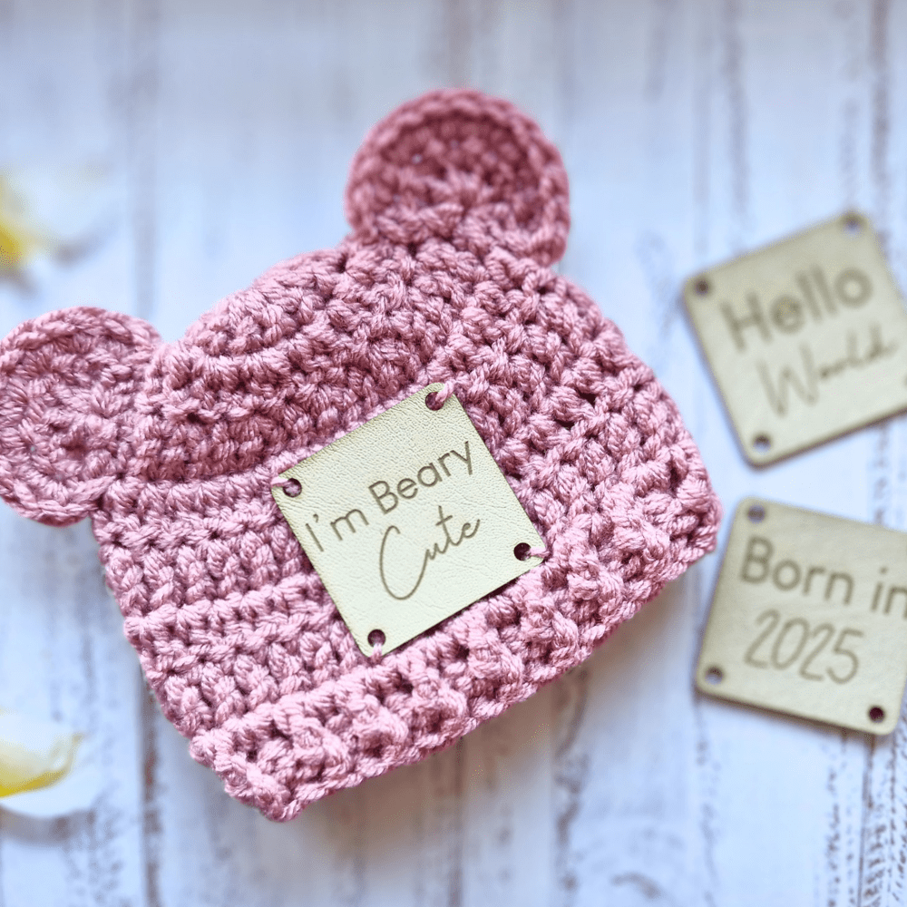 Handmade Crochet bear hat with leather patch, a choice of I'm Beary Cute, Born In 2025 or Hello World, pictured in pale rose