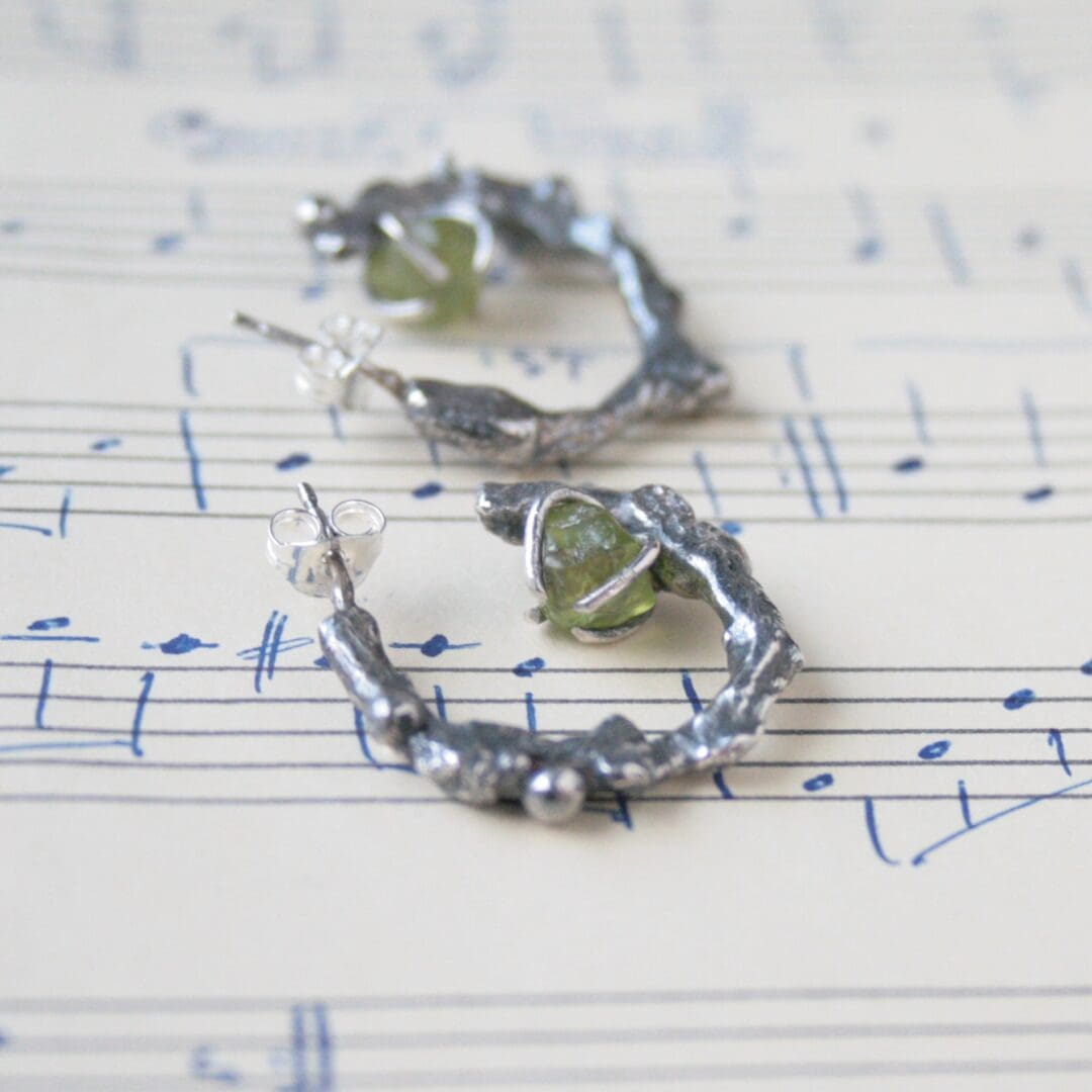 Silver twig hoop earrings with peridot gemstones