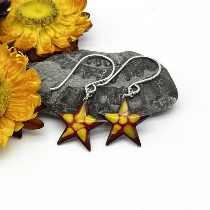 star shaped earrings enamelled in red with yellow highlights on silver ear wires