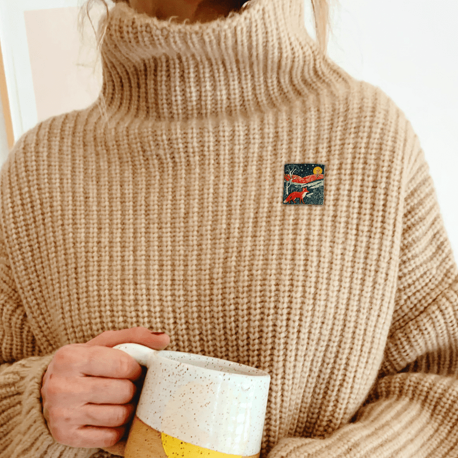 Clay fox brooch shown being worn on a cosy sweater.