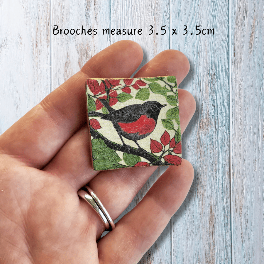 A little bird on a handmade clay brooch.