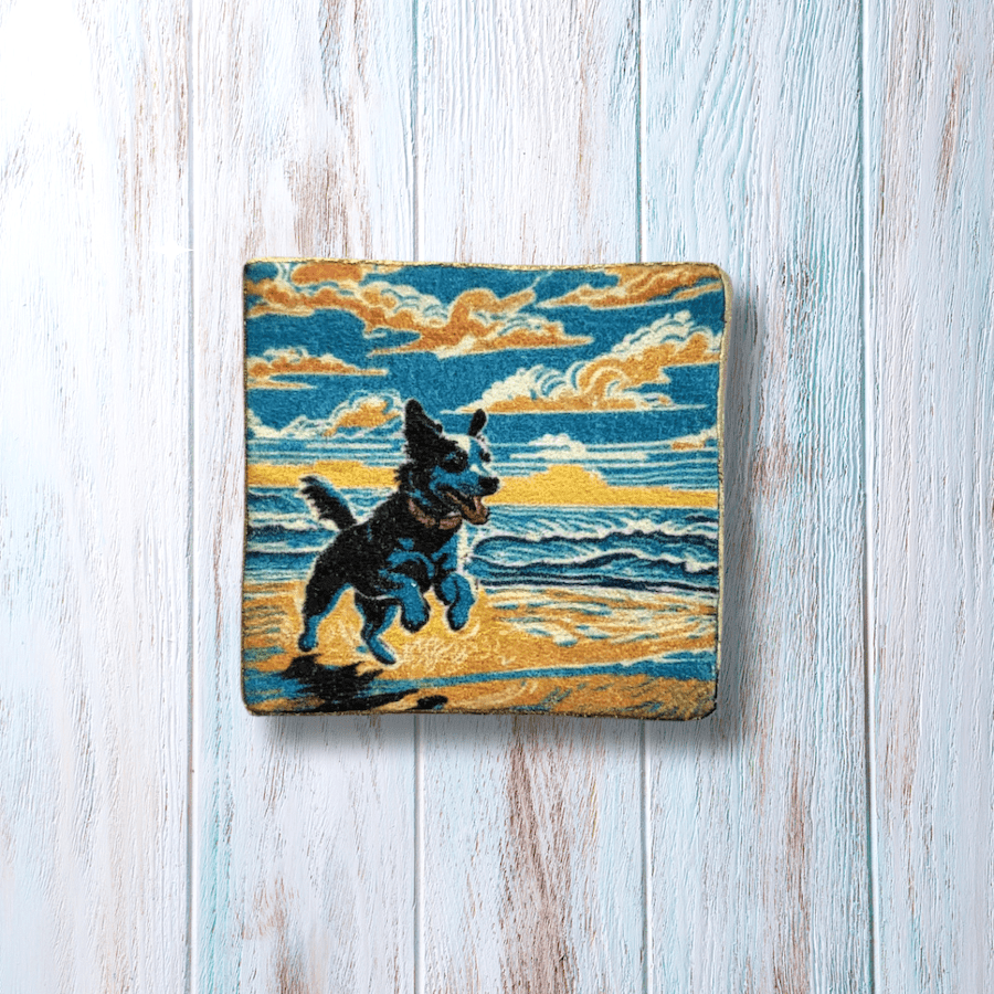 A square brooch with a happy dog on a beach.