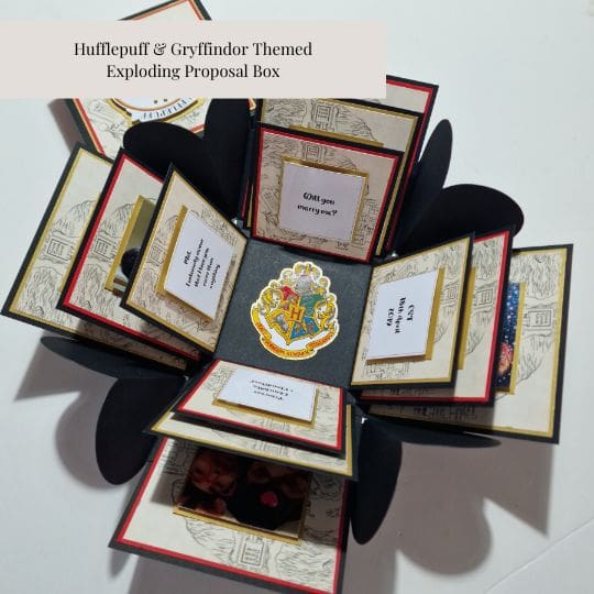 The image shows an 'exploding' proposal box themed around the Hufflepuff and Gryffindor houses from the Harry Potter series. The box is designed to open up in multiple layers, revealing various compartments and messages. The central compartment features the Hogwarts crest. The messages in the compartments include: 'Will you marry me?', 'I love you,' and 'I can't wait to marry you!