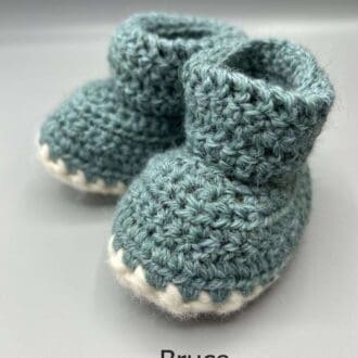 Pair of 100% Scottish Wool Baby soft shoes booties. Presented with a tartan ribbon and box. Handmade in Scotland by Midge Porter Design as part of the 'Peedie Naturals' Clan colours range - Bruce