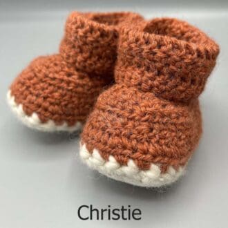 Pair of 100% Scottish Wool Baby soft shoes booties. Presented with a tartan ribbon and box. Handmade in Scotland by Midge Porter Design as part of the 'Peedie Naturals' Clan colours range - Christie