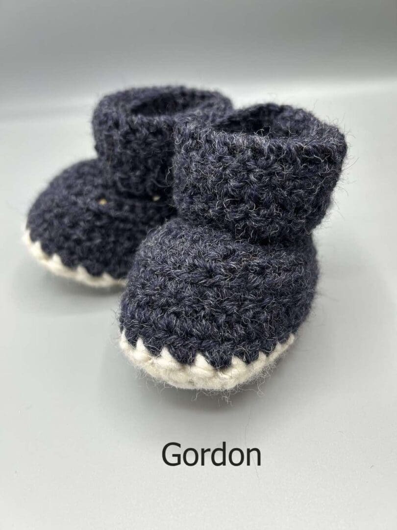 Pair of 100% Scottish Wool Baby soft shoes booties. Presented with a tartan ribbon and box. Handmade in Scotland by Midge Porter Design as part of the 'Peedie Naturals' Clan colours range - Gordon