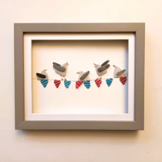 framed picture of seagulls on stripy bunting all made from nuggets of cornish sea glass